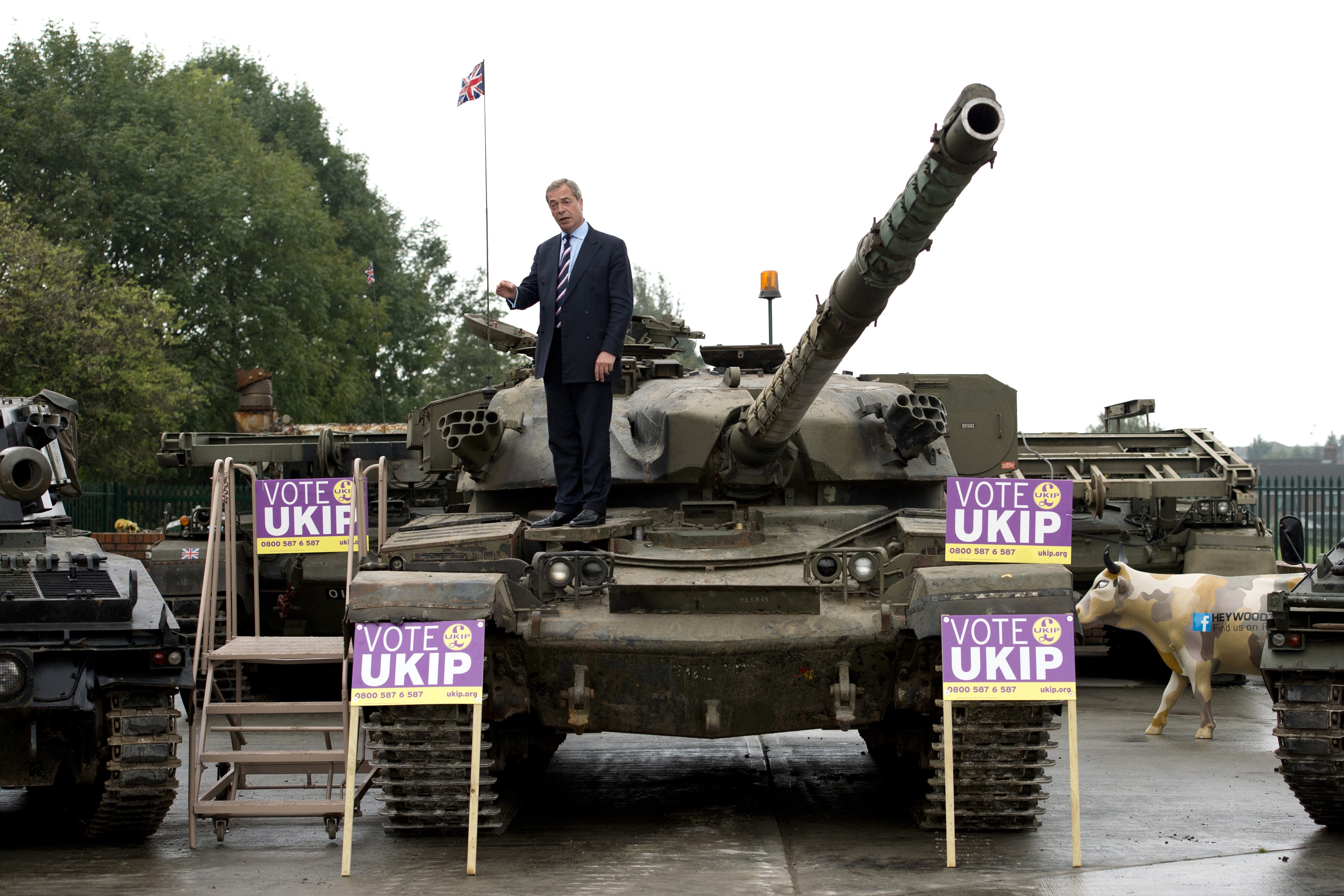 Nigel Farage, leader of the UK Independence Party (UKIP), poses for a photograph on top of a Chieftain tank at the Heywood Tank Museum in Heywood, Greater Manchester, on October 7, 2014, during his visit to the Heywood and Middleton by-election campaign.  AFP PHOTO / OLI SCARFF        (Photo credit should read OLI SCARFF/AFP/Getty Images)