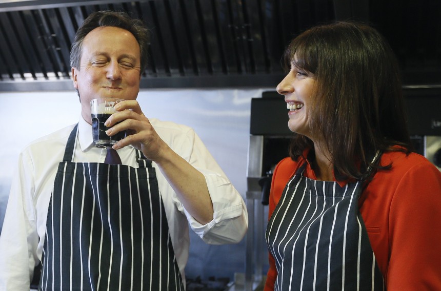 Britain's Prime Minister David Cameron has a sip of stout by his wife Samantha during a visit to Brains Brewery in Cardiff, Wales on April 7, 2015 while on the campaign trail. Britain holds a general election on May 7 in which Prime Minister David Cameron's Conservatives, senior partners in a coalition government since 2010, will seek enough support to govern alone. AFP PHOTO / POOL / Kirsty Wigglesworth        (Photo credit should read KIRSTY WIGGLESWORTH/AFP/Getty Images)