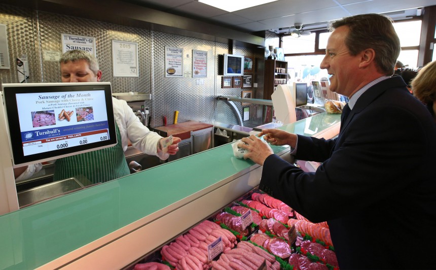 Britain's Prime Minister David Cameron buys some saudages in a butchers shop as he campaigns in Alnwick
